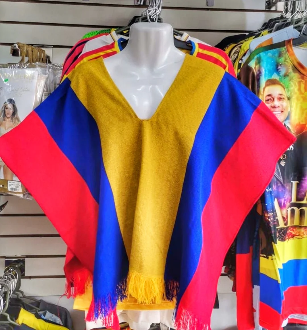 Cuatro ponchos colombianos de diferentes diseños y colores exhibidos en maniquíes blancos